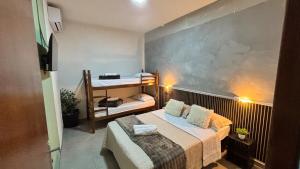 a small room with a bed and a couple of bunk beds at Apto 05 - A&N Estadia Premium - Centro Bandeirantes PR in Bandeirantes +18 photos