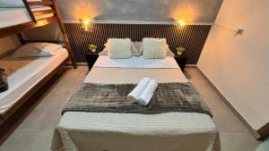 a bedroom with two beds with towels on them at Apto 05 - A&N Estadia Premium - Centro Bandeirantes PR in Bandeirantes