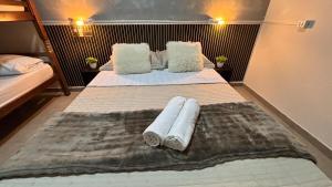 two beds in a room with towels on them at Apto 05 - A&N Estadia Premium - Centro Bandeirantes PR in Bandeirantes