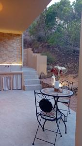 a patio with a table and chairs and stairs at Appartamento "Hic et Nunc" in Costa Paradiso