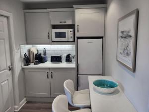 a kitchen with white cabinets and a bowl on a table at Garavogue Villa in Sligo