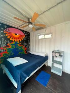 a bedroom with a bed with a painting on the wall at Peace Hostel MX in La Paz
