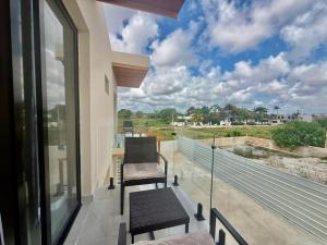 a balcony with two chairs and a view of a field at Paradise Cove in Punta Cana