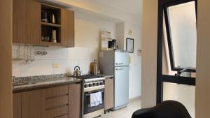 a kitchen with a stove and a refrigerator at "REFUGIO EN LA TERRAZA" - WiFi 300mbs in Santiago del Estero
