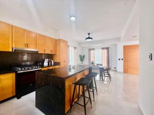 a kitchen with wooden cabinets and a black counter top at Paradise Cove in Punta Cana