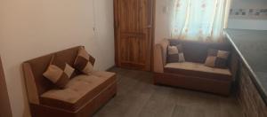 a living room with a couch and two chairs at Los Ceibos Hostal in Montecristi +1 photo