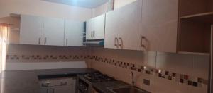 a kitchen with white cabinets and a sink at Los Ceibos Hostal in Montecristi