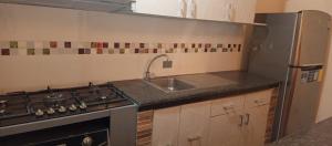 a small kitchen with a sink and a stove at Los Ceibos Hostal in Montecristi