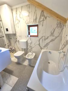 a bathroom with a tub and a toilet and a sink at Villa DORA in Vrbovsko
