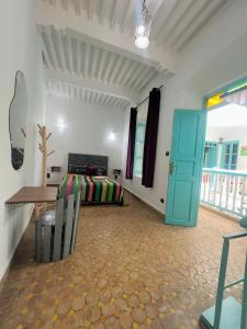 a room with a bed and a table and a door at Riad Darko in Essaouira +22 photos