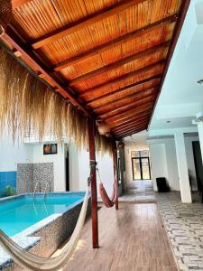 a hammock in a resort with a swimming pool at Hospedaje Dora in Máncora