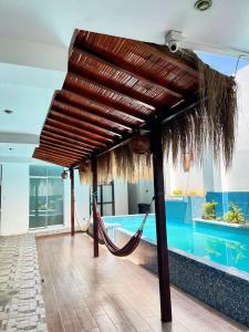 a hammock in a resort with a swimming pool at Hospedaje Dora in Máncora