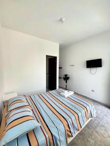 a bedroom with a large bed with a television on the wall at Hospedaje Dora in Máncora
