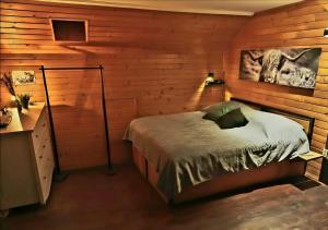 a bedroom with a bed in a wooden wall at Komondor Vendégház in Vácrátót