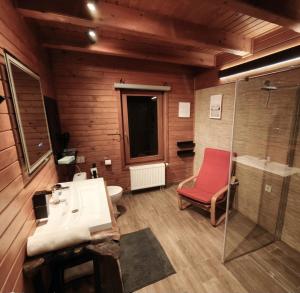 a bathroom with a sink and a red chair at Komondor Vendégház in Vácrátót +21 photos