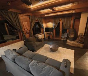 a living room with a blue couch and a living room with a television at Komondor Vendégház in Vácrátót