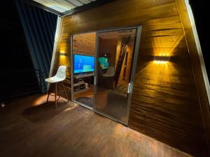 a room with a mirror and a television on a wooden wall at Cabañas The Twins in Medellín