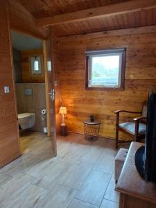 a bathroom in a log cabin with a window at Blokhut Bron van Rust in Opende