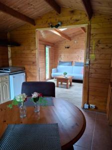 a wooden living room with a table and a couch at Blokhut Bron van Rust in Opende