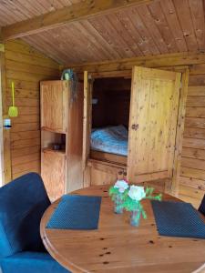 a room with a table and a bed in a cabin at Blokhut Bron van Rust in Opende