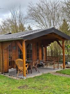 a pavilion with a table and chairs on a patio at Blokhut Bron van Rust in Opende