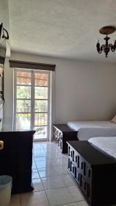 a room with two beds and a large window at Los Pueblitos de Guanajuato in Guanajuato +9 photos