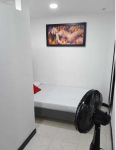 a room with a fan and a painting on the wall at Hospedajes Gold in Cali