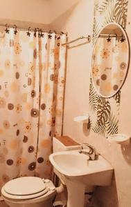 a bathroom with a sink and a toilet and a mirror at Teros in Caleta Olivia +8 photos