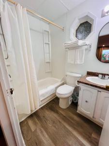 a white bathroom with a toilet and a sink at SUMMERSIDE MOTEL &COTTAGES in Summerside +13 photos