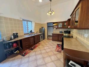 a large kitchen with wooden cabinets and a large floor at Palm Villa Hideaway in Diani Beach +6 photos
