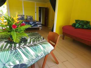 a room with a table and a chair and a couch at Hitirā Lodge presqu'île in Atihiva