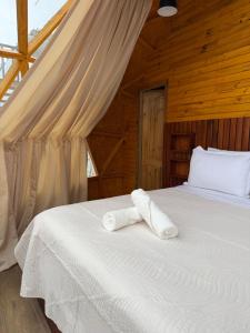 a bedroom with a bed with white sheets at Helite Arena y Mar in Puerto Cayo +40 photos