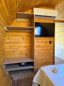 a room with a bed and a tv in a cabin at Helite Arena y Mar in Puerto Cayo