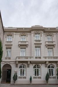 a large white building with windows and gates at Matildas Hotel Boutique in Santiago