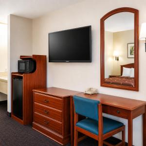 a hotel room with a desk and a mirror at TrueStay Inn in Bakersfield