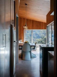 a kitchen with a large window and a dining table at Threefold in Swansea