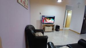 a living room with a couch and a tv at La Reina in San Rafael