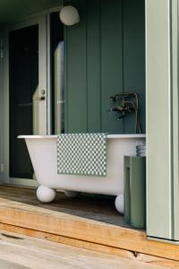 a bath tub in a bathroom with a mirror at Threefold in Swansea