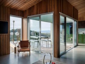 a room with glass doors and a chair and a table at Threefold in Swansea