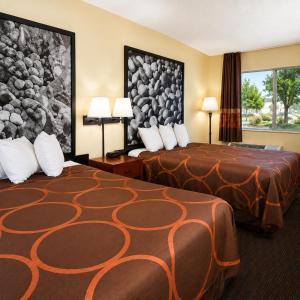 a hotel room with two beds and a painting on the wall at TrueStay Inn in Bakersfield +6 photos