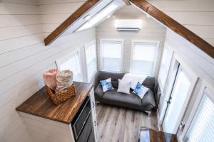 a living room with a couch and a chair at Tiny Home with Private Hot Tub, Zion Adventure Base in Apple Valley