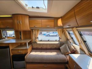 an interior of an rv with a couch and a window at La Rulote in Căpăţîneni-Ungureni