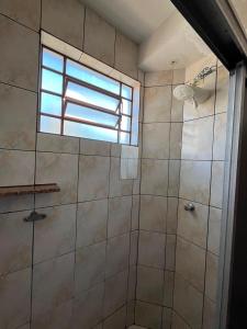 a bathroom with a shower with a window at Apartamento simples no centro de Lavras com garagem in Lavras +1 photo