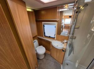 a small bathroom with a toilet and a sink at La Rulote in Căpăţîneni-Ungureni +25 photos