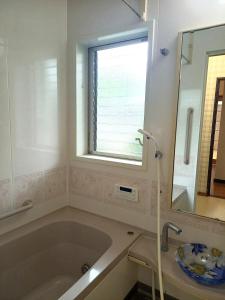 a bathroom with a large tub and a window at 一棟貸切民宿Saisai 3部屋 in Sakai +13 photos