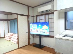 a room with a flat screen tv on a wall at 一棟貸切民宿Saisai 3部屋 in Sakai