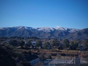 Eine Stadt mit schneebedeckten Bergen im Hintergrund in der Unterkunft ClCabañas in Huerta Grande