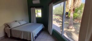 a bedroom with a bed next to a window at Cabana acogedora rodeada de naturaleza in San Bruno