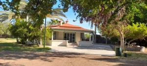 a small house with a red roof in a park at Cabana acogedora rodeada de naturaleza in San Bruno +2 photos