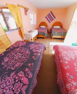 a room with three beds in a room at casa inti lodge in Isla Amantani